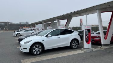 Lynlad elbilen kvit og frit på en Tesla Supercharger